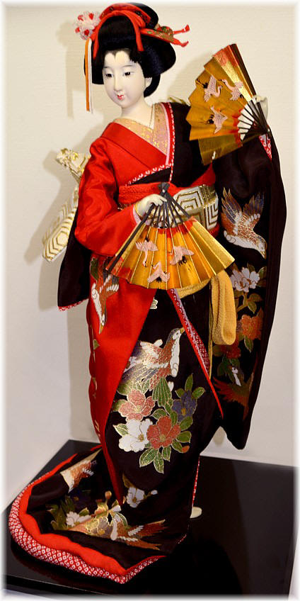 Japanese tradiitional doll of a danciing woman with two golden fans