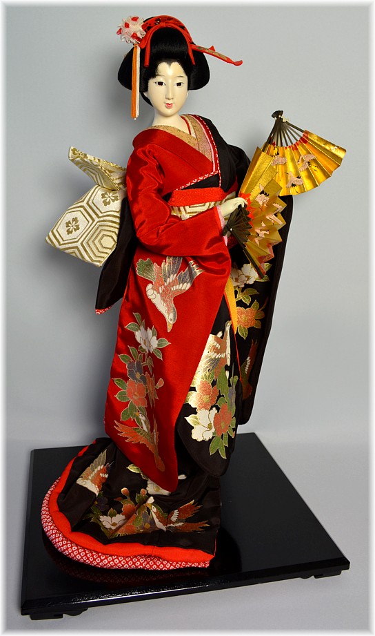 Japanese tradiitional doll of a danciing woman with two golden fans