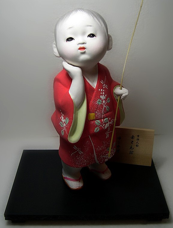 Japanese Hakata ceramic doll of a Boy with twig