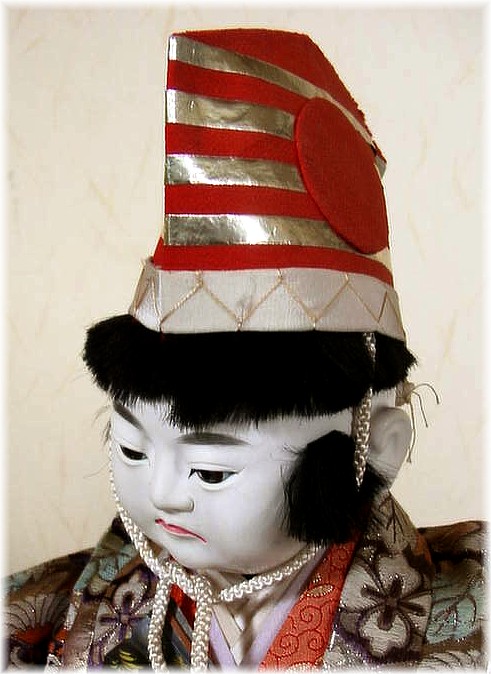 japanese antique doll of a boy with high striped hat