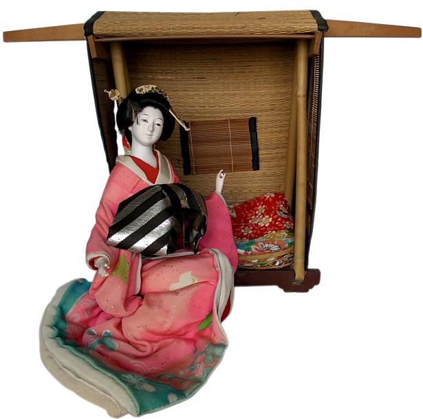 japanese antique geisha doll sitting in straw carriage