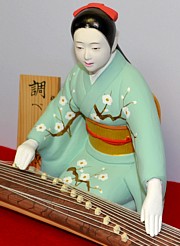 japanese hakata doll of a young woman playing koto, 1950's