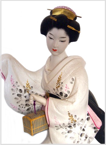 japanese clay doll of a woman with cage